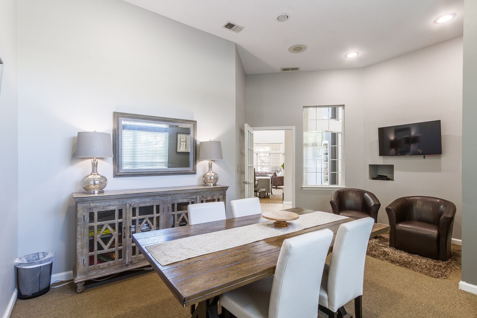 Resident busines center with table, chairs, buffet, mirror, chairs, and TV. Neutral walls and carpet. Tour spacious 2-bedroom apartments for rent in Lexington, KY designed for flexibility.