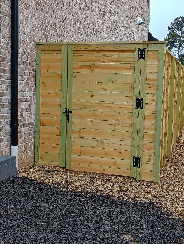 a wooden shed is sitting next to a brick building