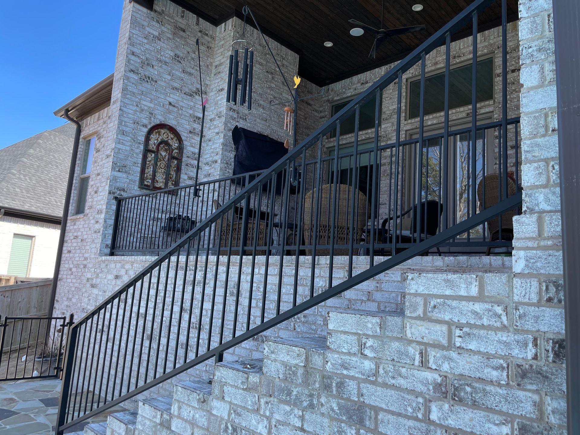 a brick building with stairs and a wrought iron railing