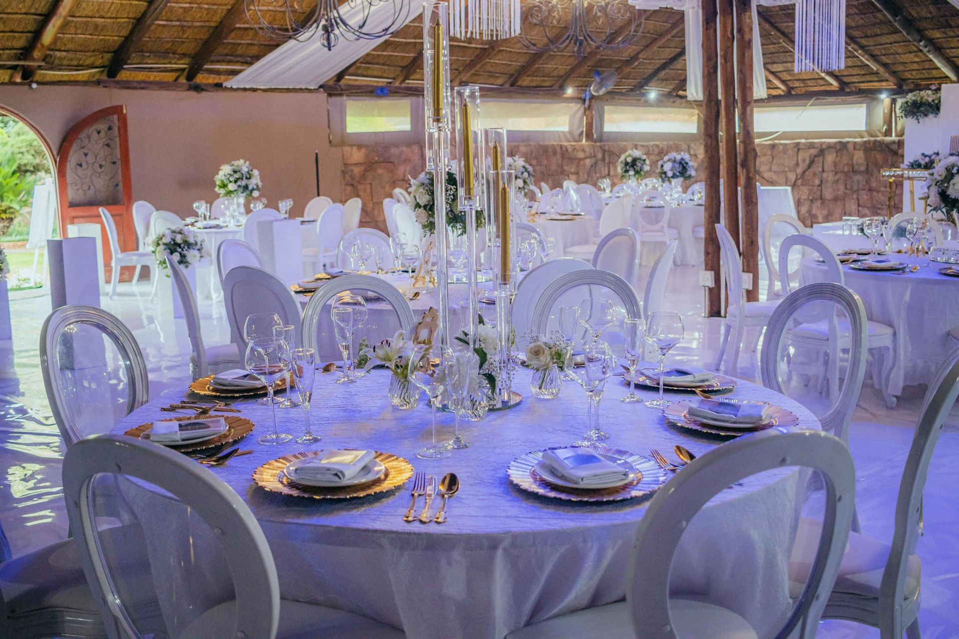 A large room with tables and chairs set up for a wedding reception.