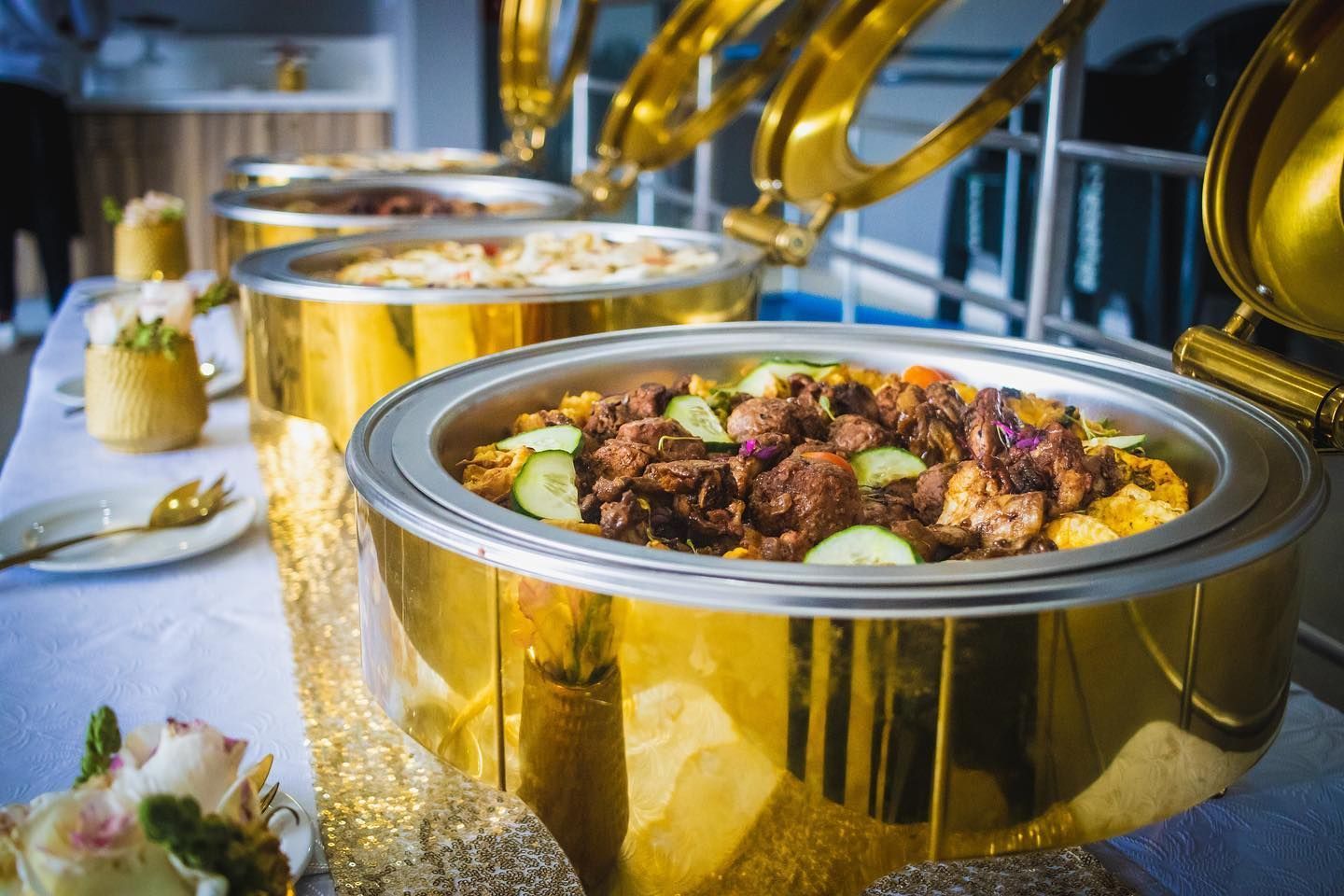 A buffet line with a variety of food on a table.