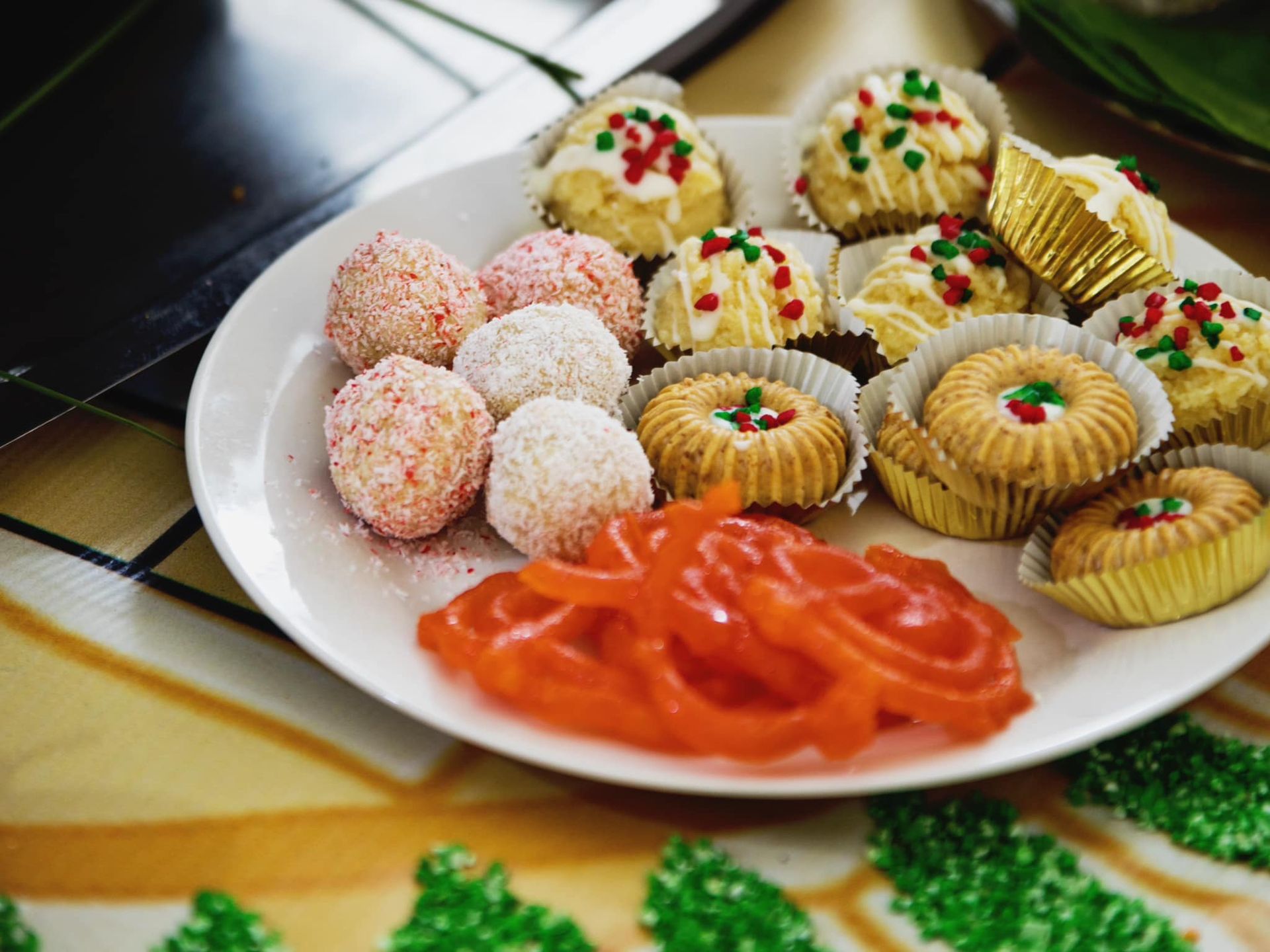 A white plate topped with a variety of desserts on a table.