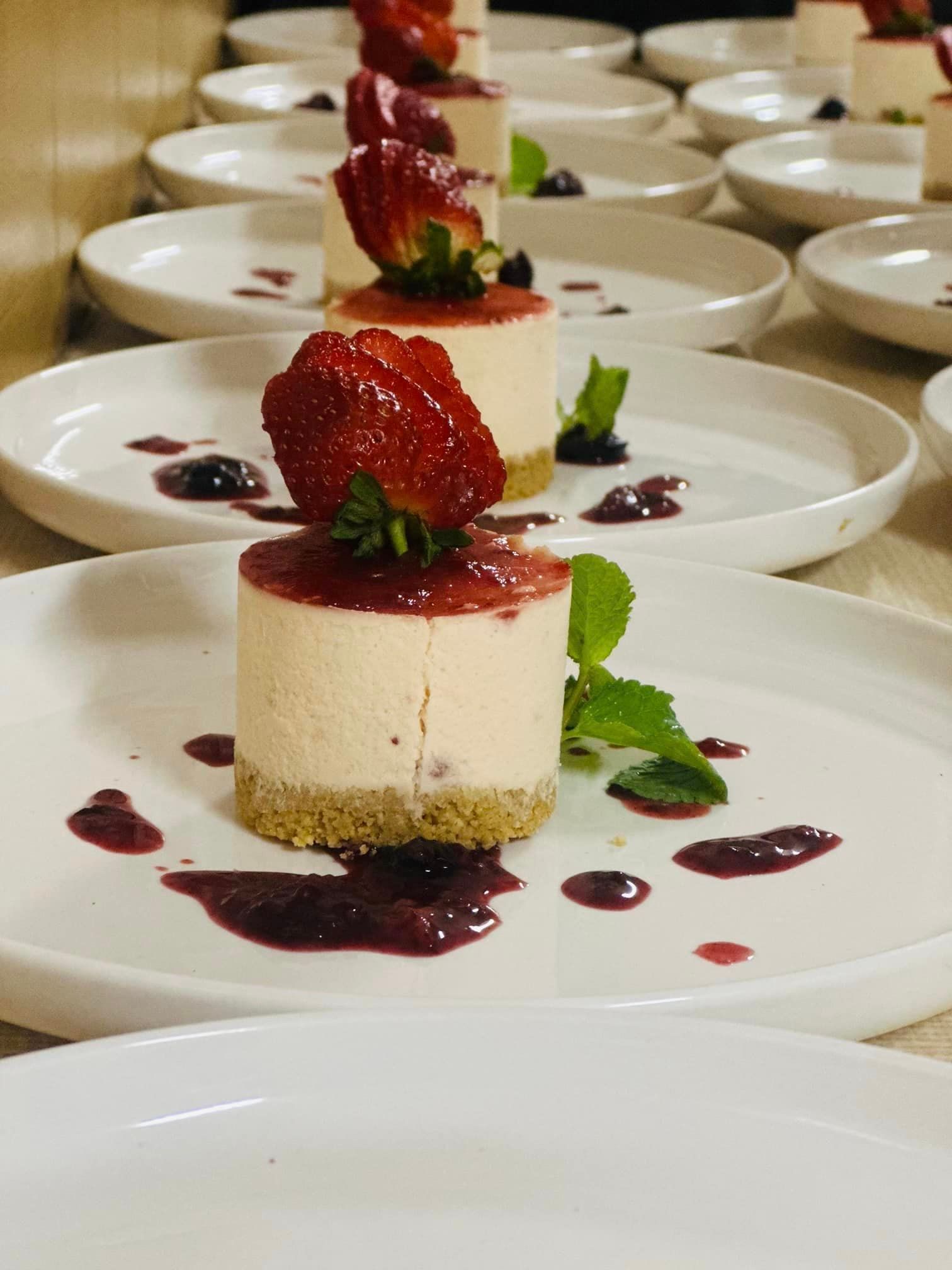 A dessert with strawberries on top is on a white plate