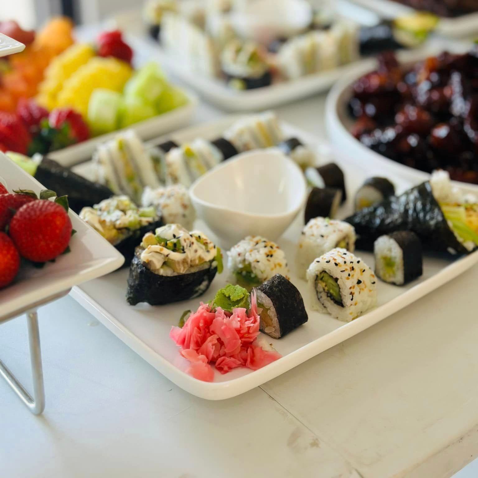 A tray of sushi and fruit on a table