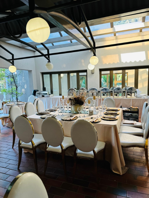 A large room with tables and chairs set up for a wedding reception.