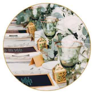 A table set for a wedding reception with flowers and wine glasses.