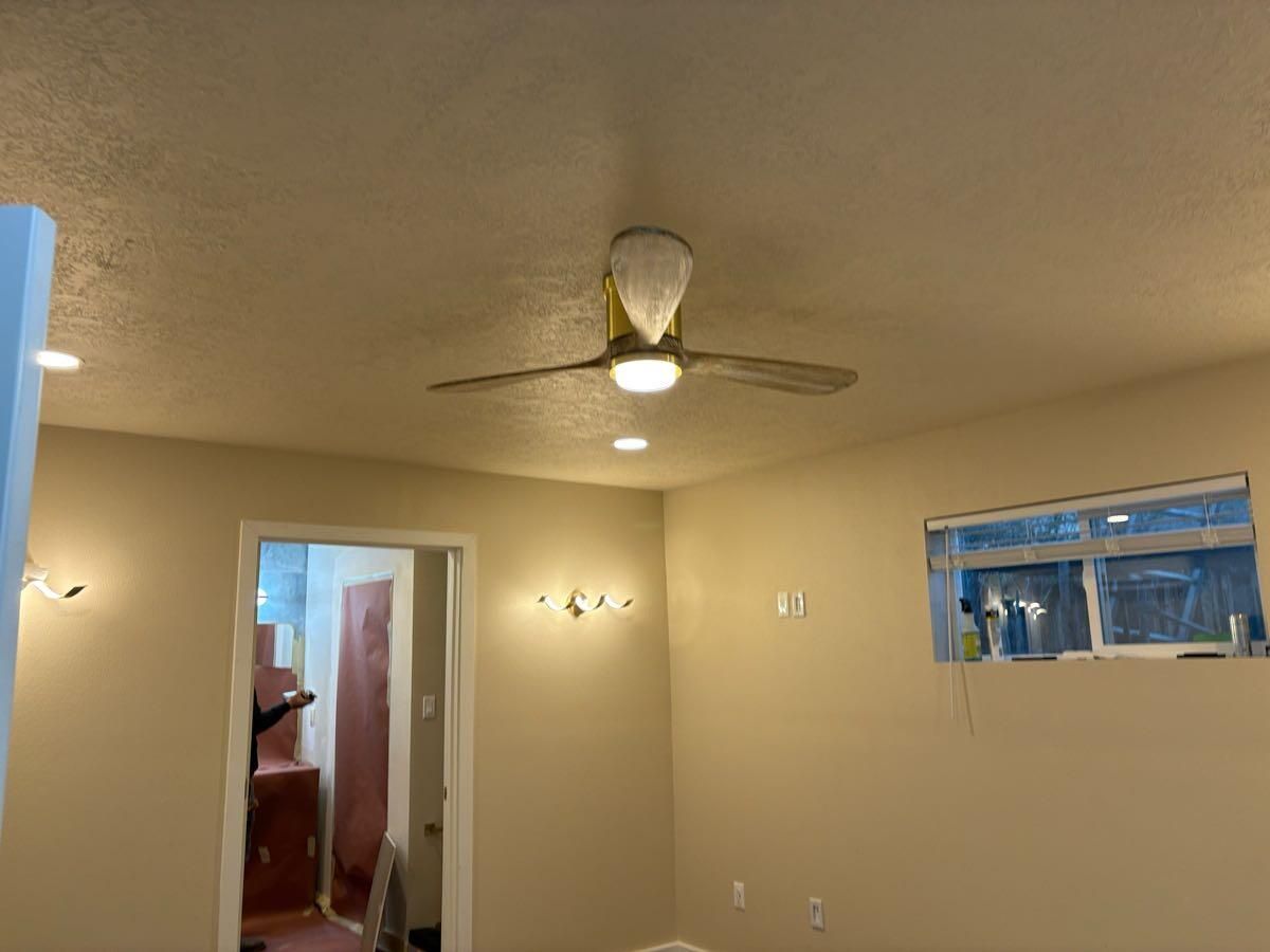 A room with a ceiling fan and a window.