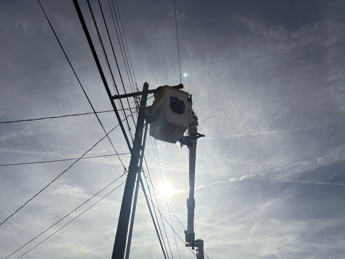 A man in a bucket is working on a power line.