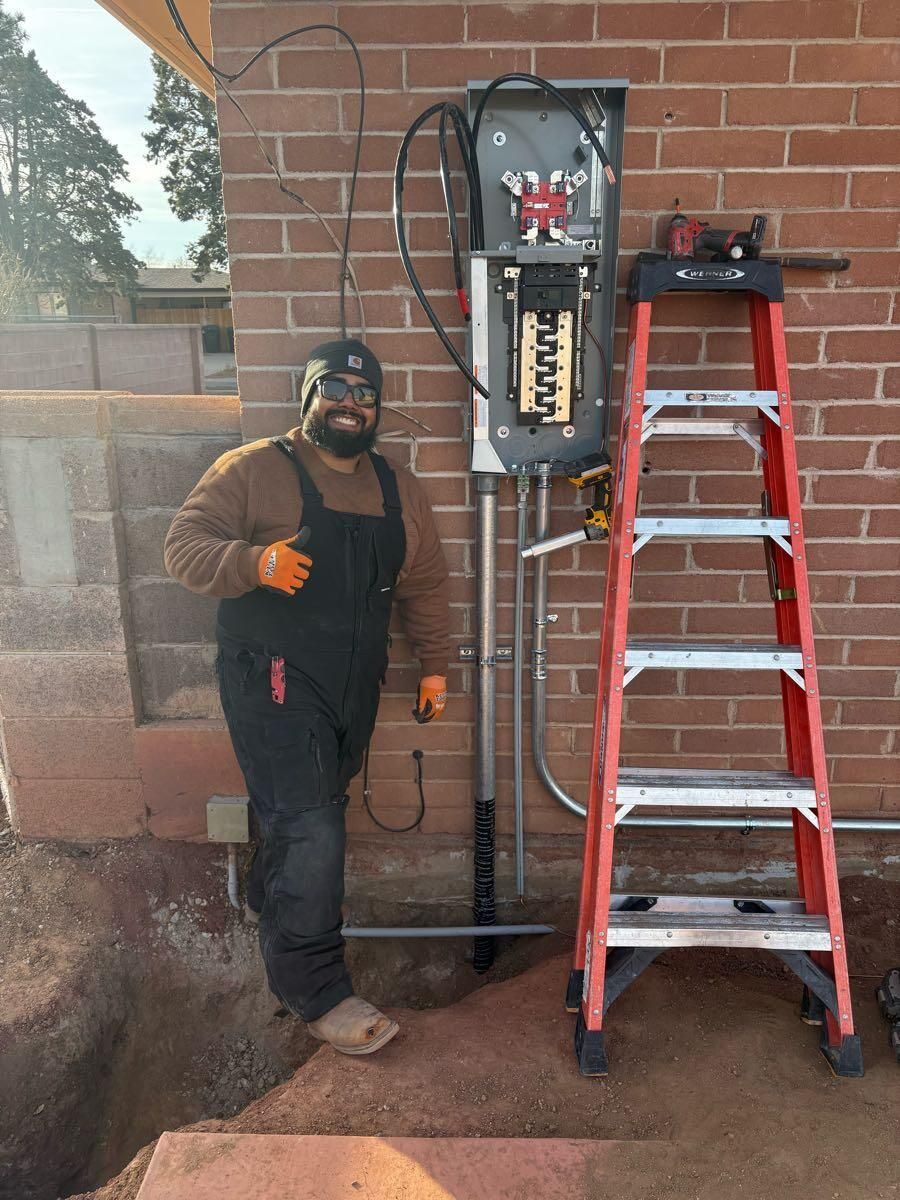 A man is standing next to a ladder in front of a brick wall.
