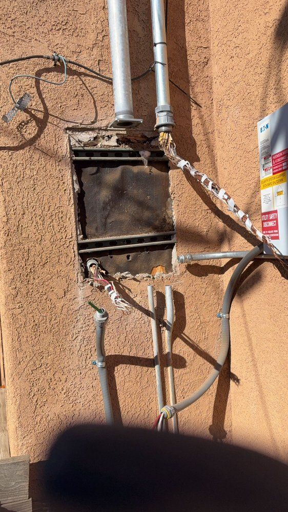 A close up of a wall with a bunch of wires coming out of it.