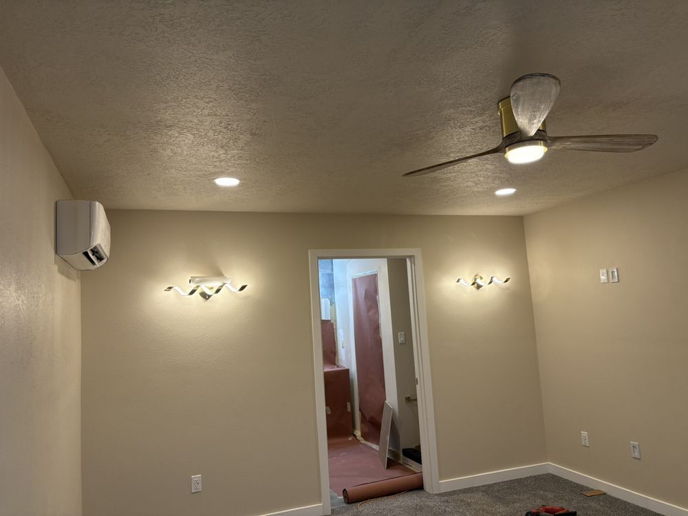 A room with a ceiling fan and a doorway leading to a bathroom.
