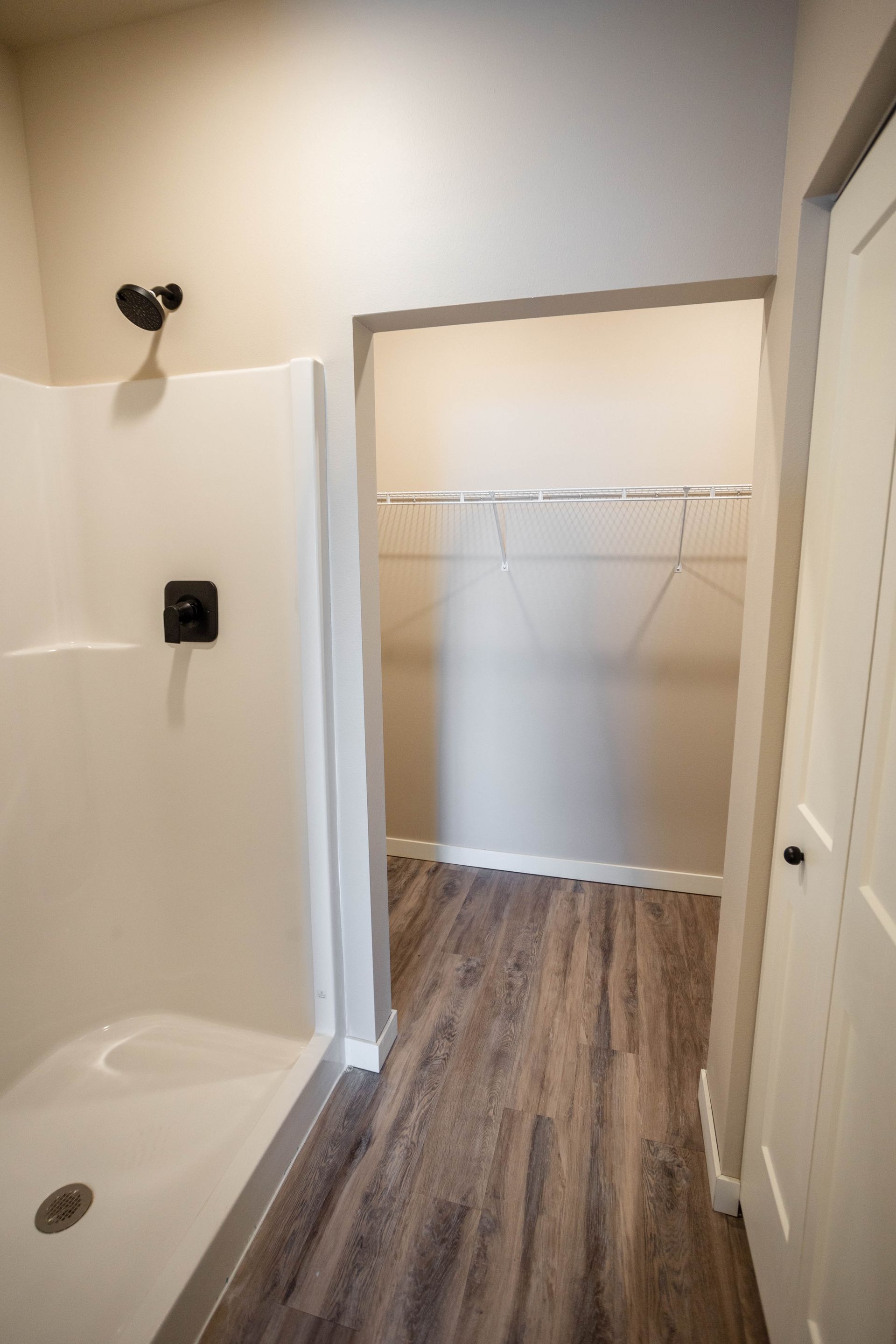 A bathroom with a walk in closet and a shower.