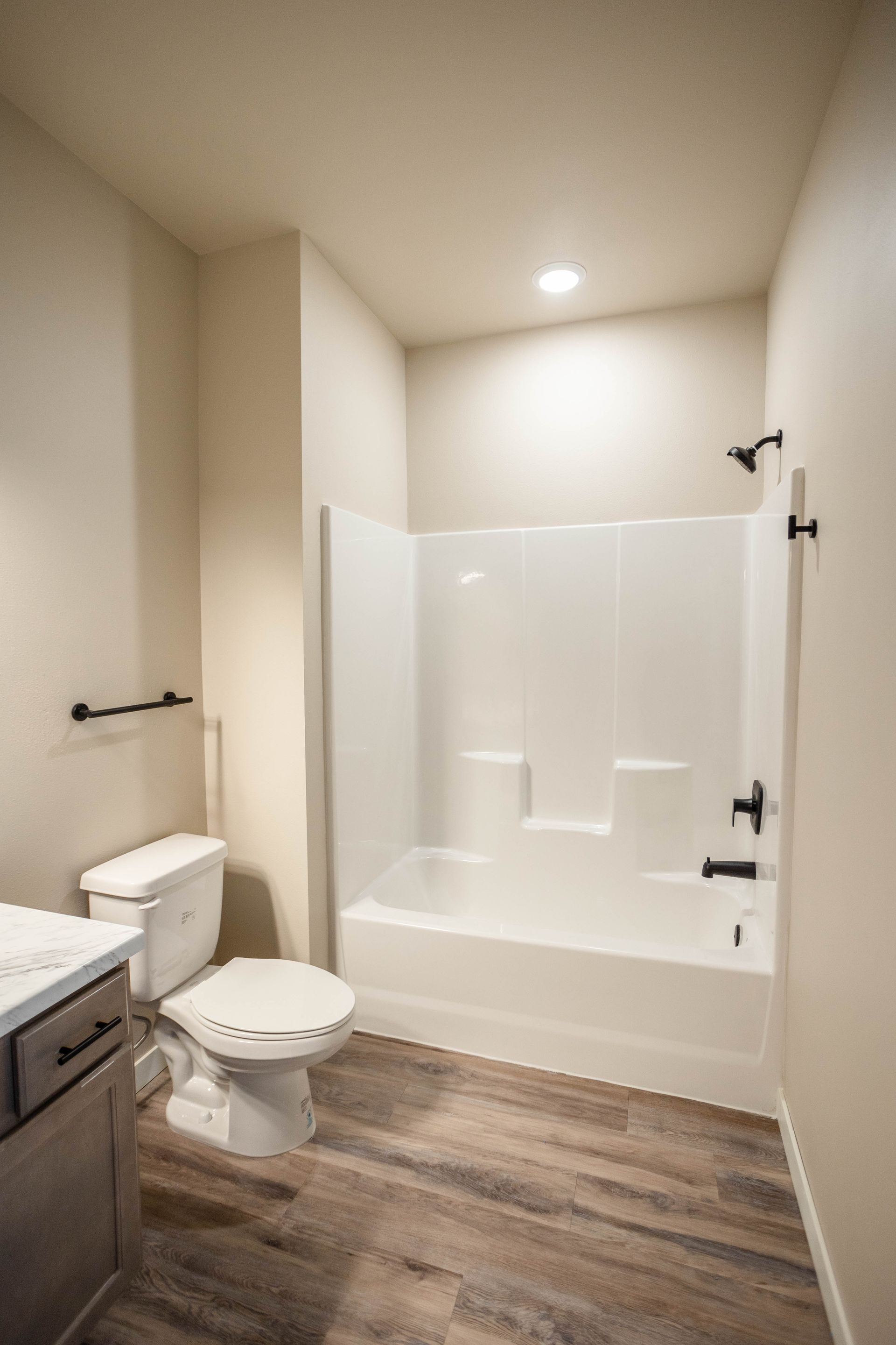A bathroom with a toilet , bathtub and shower.