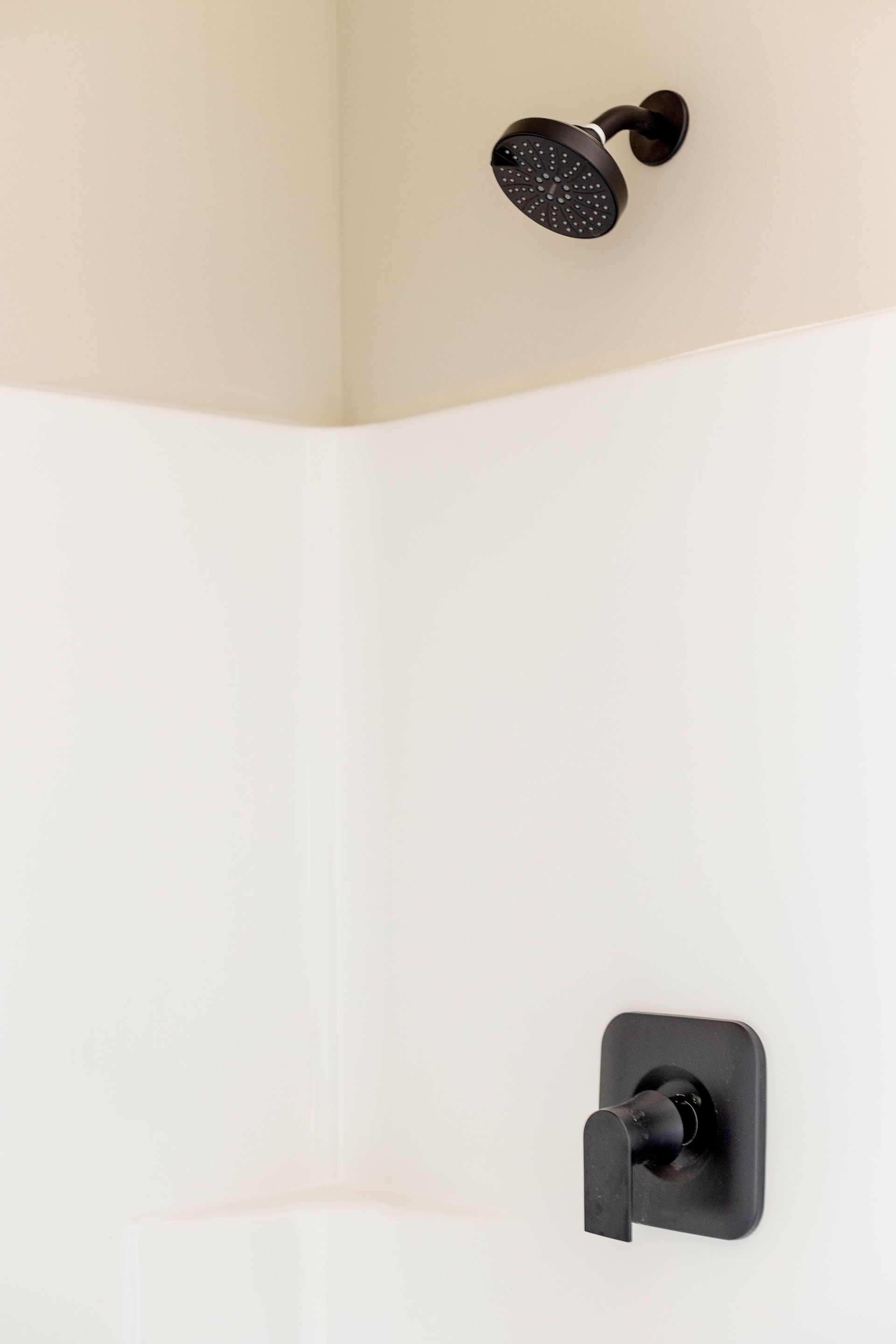 A shower head is hanging from the ceiling in a bathroom.