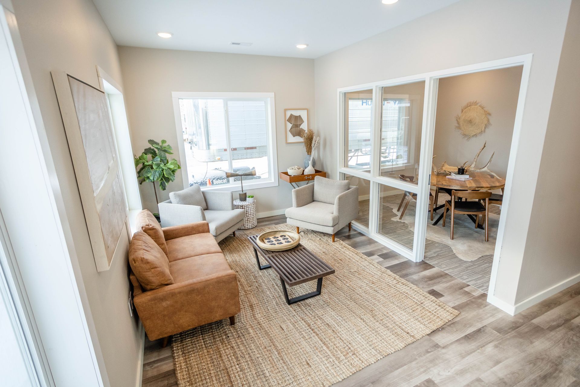 A living room with a couch , chairs , and a coffee table.