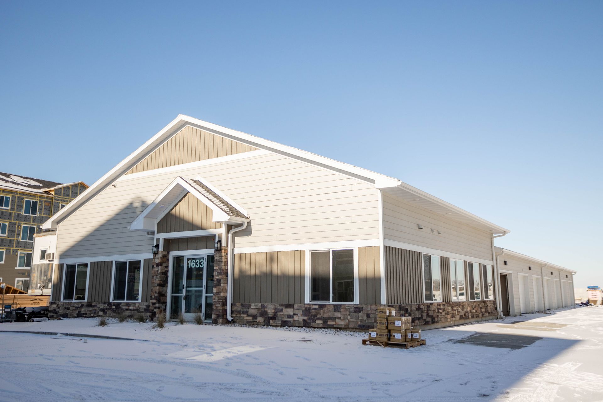 A large building with a lot of windows is covered in snow.