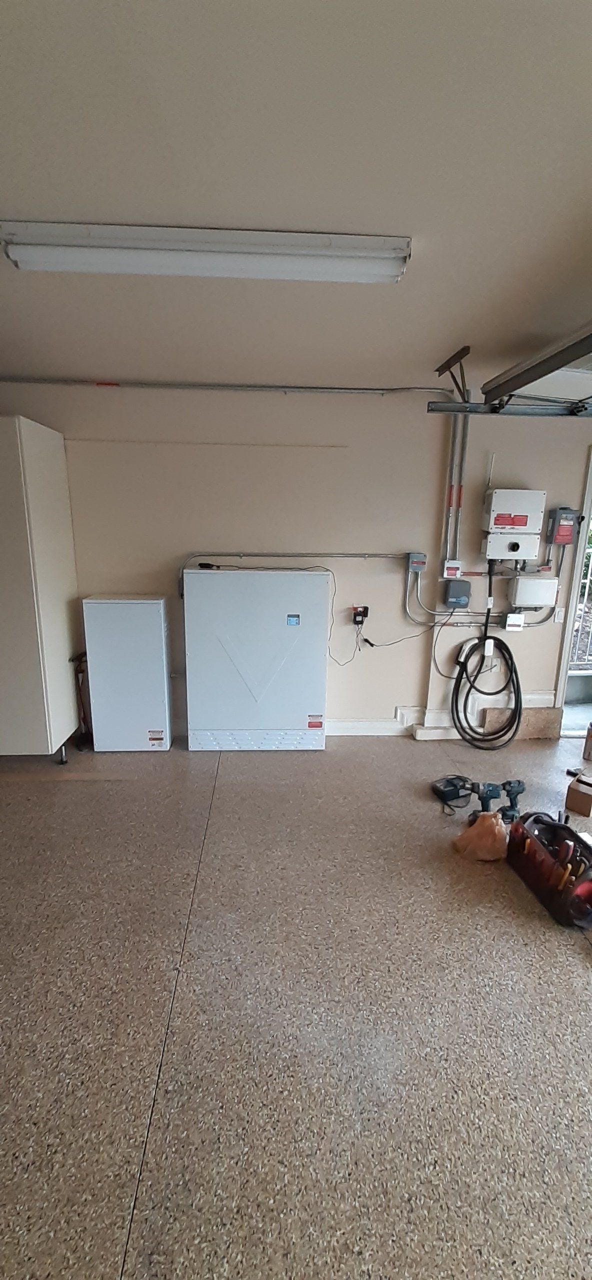 Garage with two white storage cabinets and speckled floor.