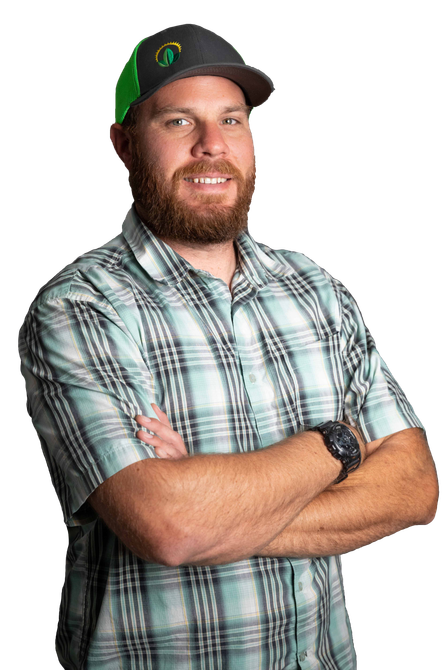 Man with a beard and hat, arms crossed, wearing a plaid shirt, smiling.