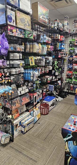 A store interior with shelves packed with various video game items and other merchandise.