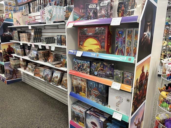 Shelves of board games and displays inside a retail store, featuring colorful boxes and signage.