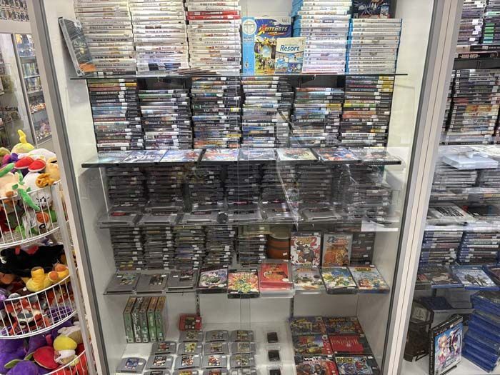 Display case filled with video games of various consoles at a shop.