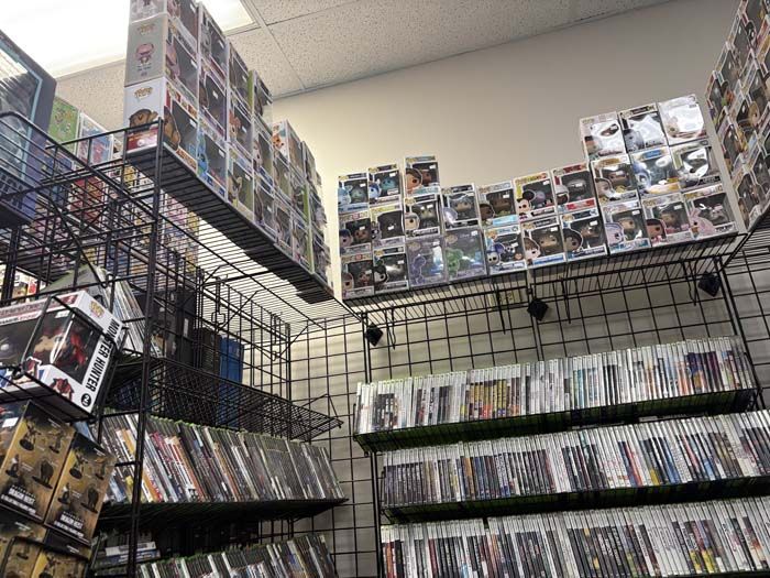 Shelves of video games and collectibles in a store.