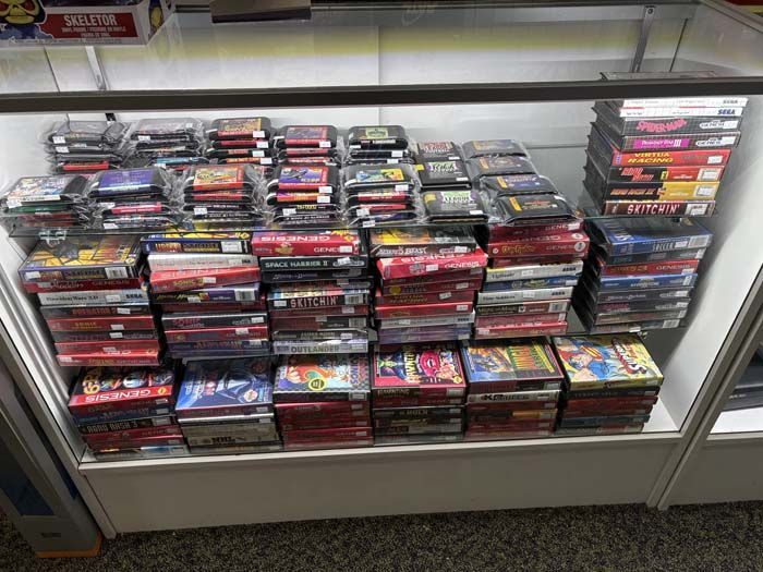 Display case filled with stacks of retro video game cartridges and boxes.