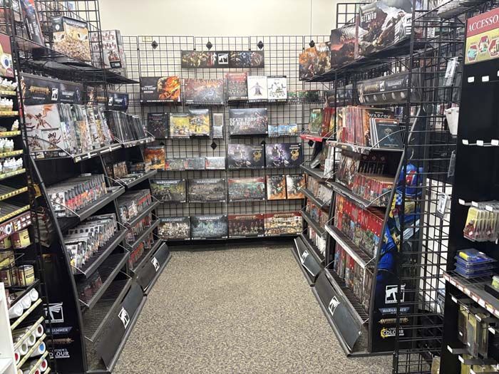 Board game aisle in a retail store with shelves displaying various game boxes.