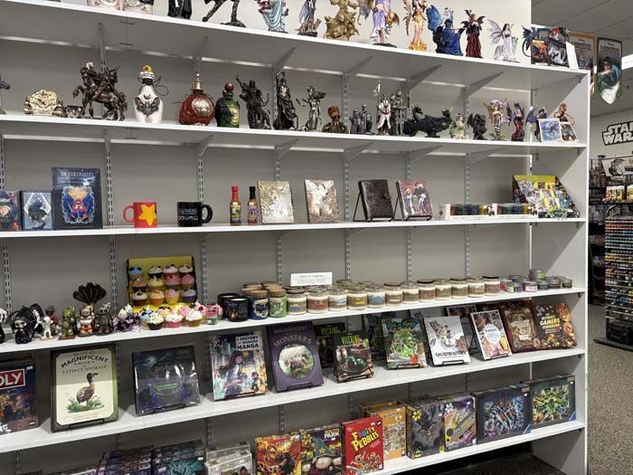 Shelves filled with figurines, mugs, and board games in a store, all on display, showcasing merchandise.