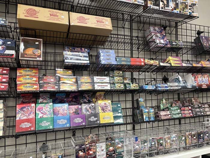 Shelves stocked with trading card game products, likely a retail store.