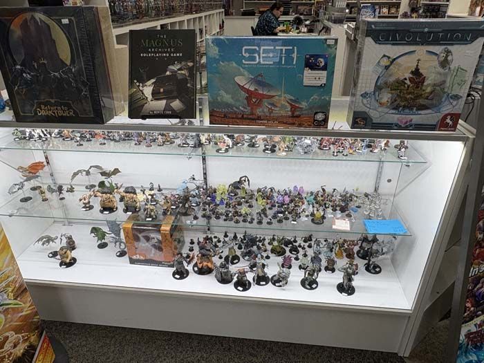 Display case with board games and miniature figurines in a store.