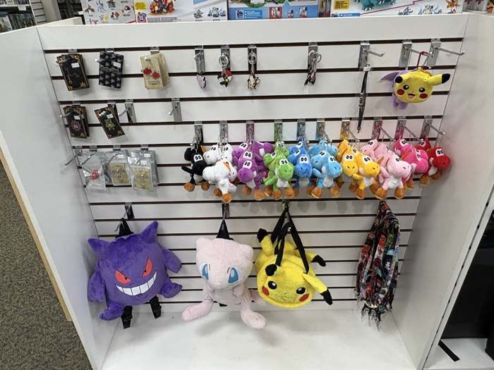 Display case with Pokémon merchandise: plush toys, keychains, and phone cases.