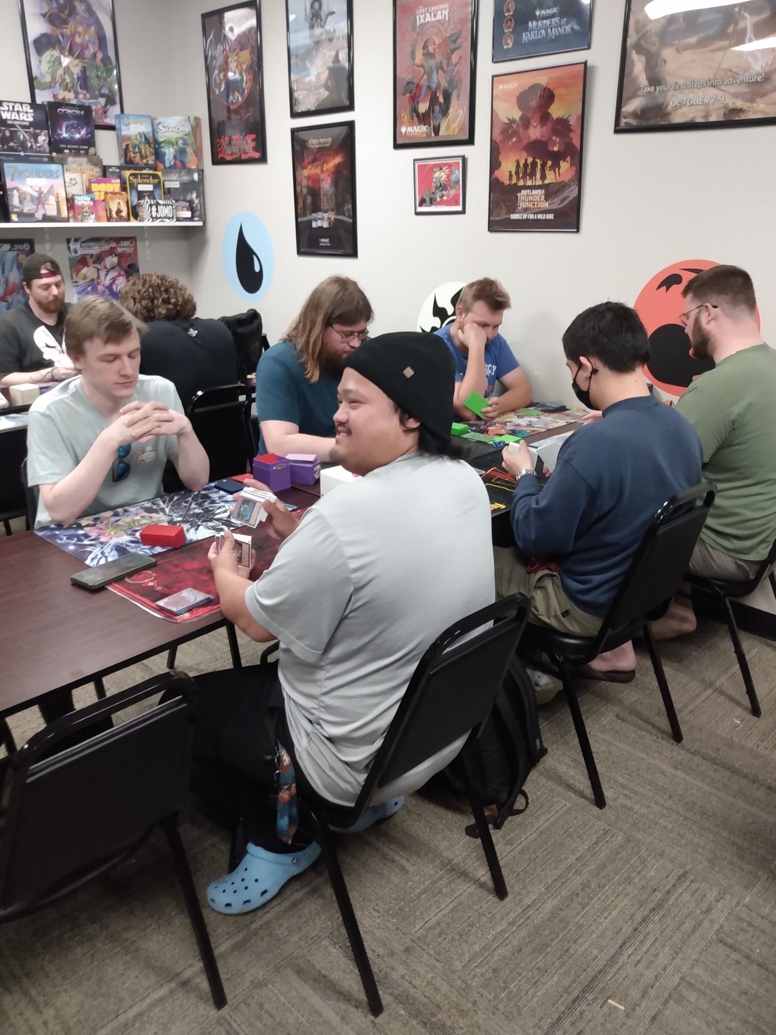 Tables lined up with players, playing tcg games.