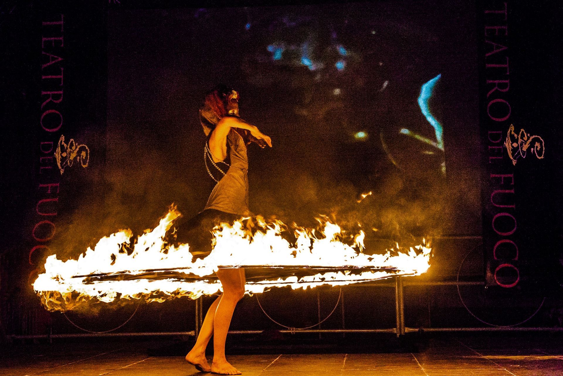 Una donna è in piedi davanti a un cerchio di fuoco con la scritta 