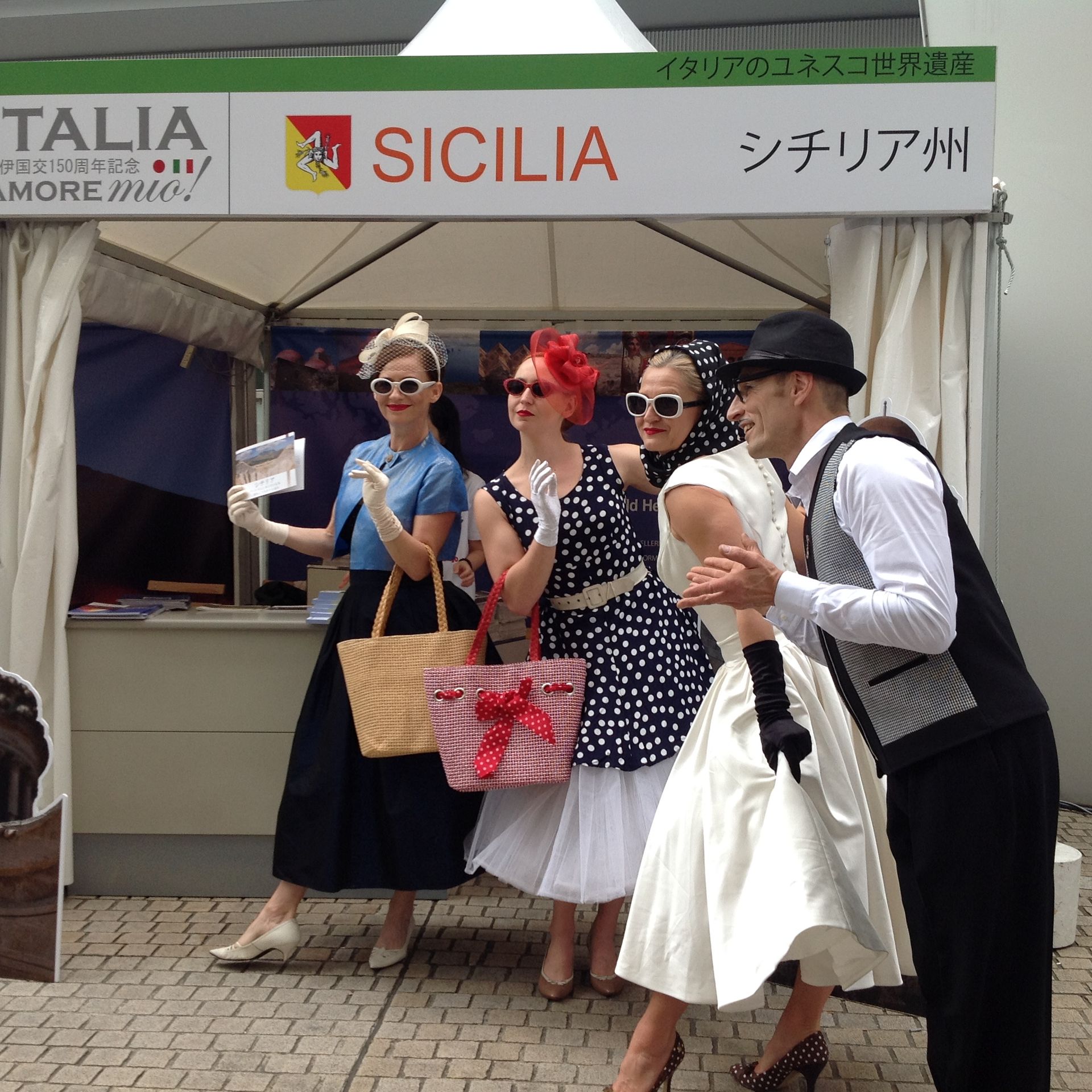 Un gruppo di persone in piedi davanti a un cartello che dice sicilia