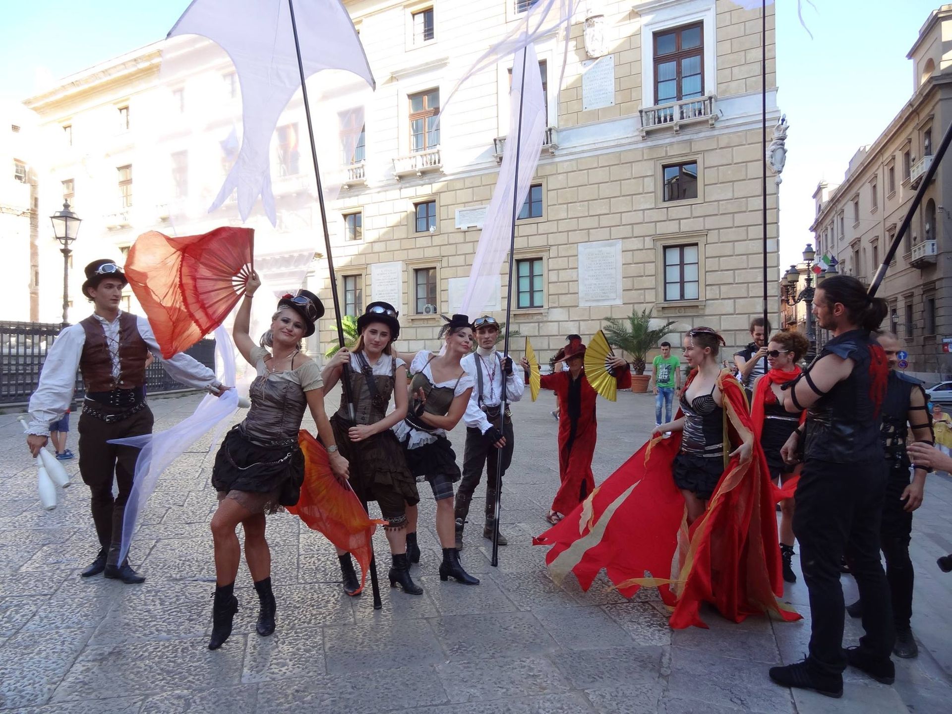 Un gruppo di persone è in piedi davanti a un edificio tenendo in mano delle bandiere