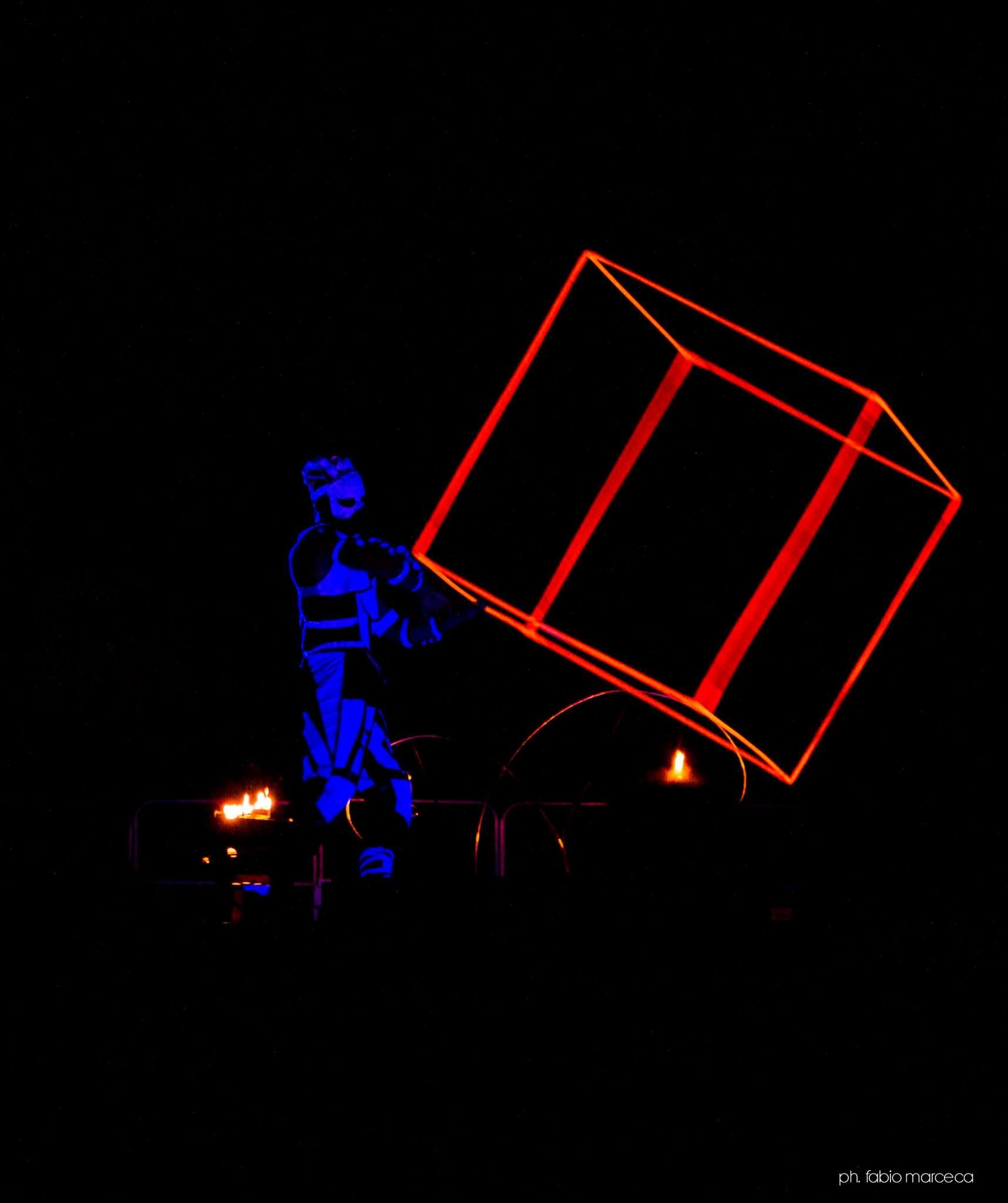 Una persona tiene in mano un cubo rosso al buio