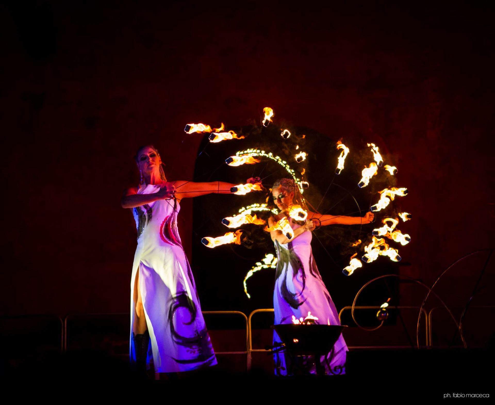 Due donne stanno eseguendo uno spettacolo di fuoco al buio