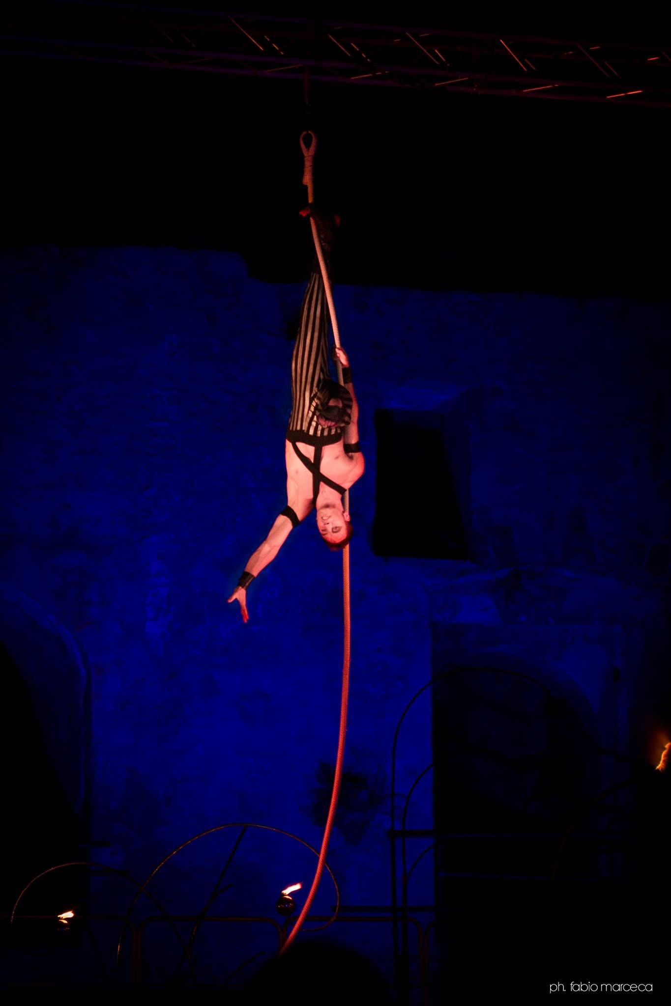 Una donna è appesa a testa in giù a una corda in aria.