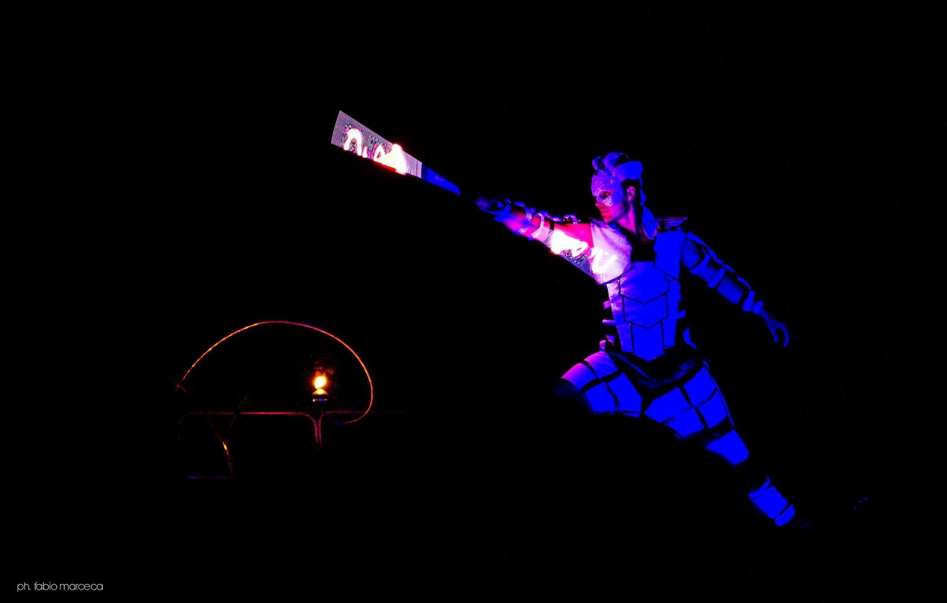 Una persona tiene in mano una torcia nell'oscurità.