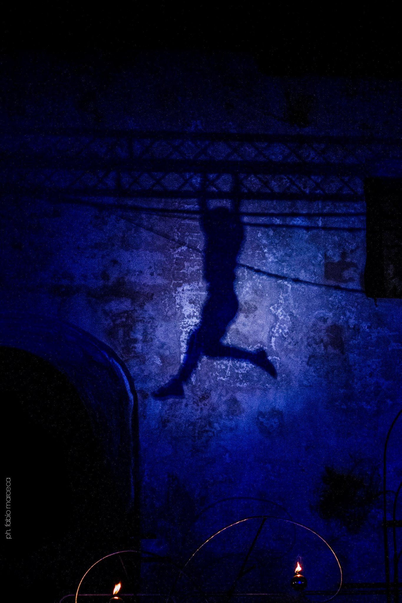 La sagoma di una persona che salta in aria nel buio.