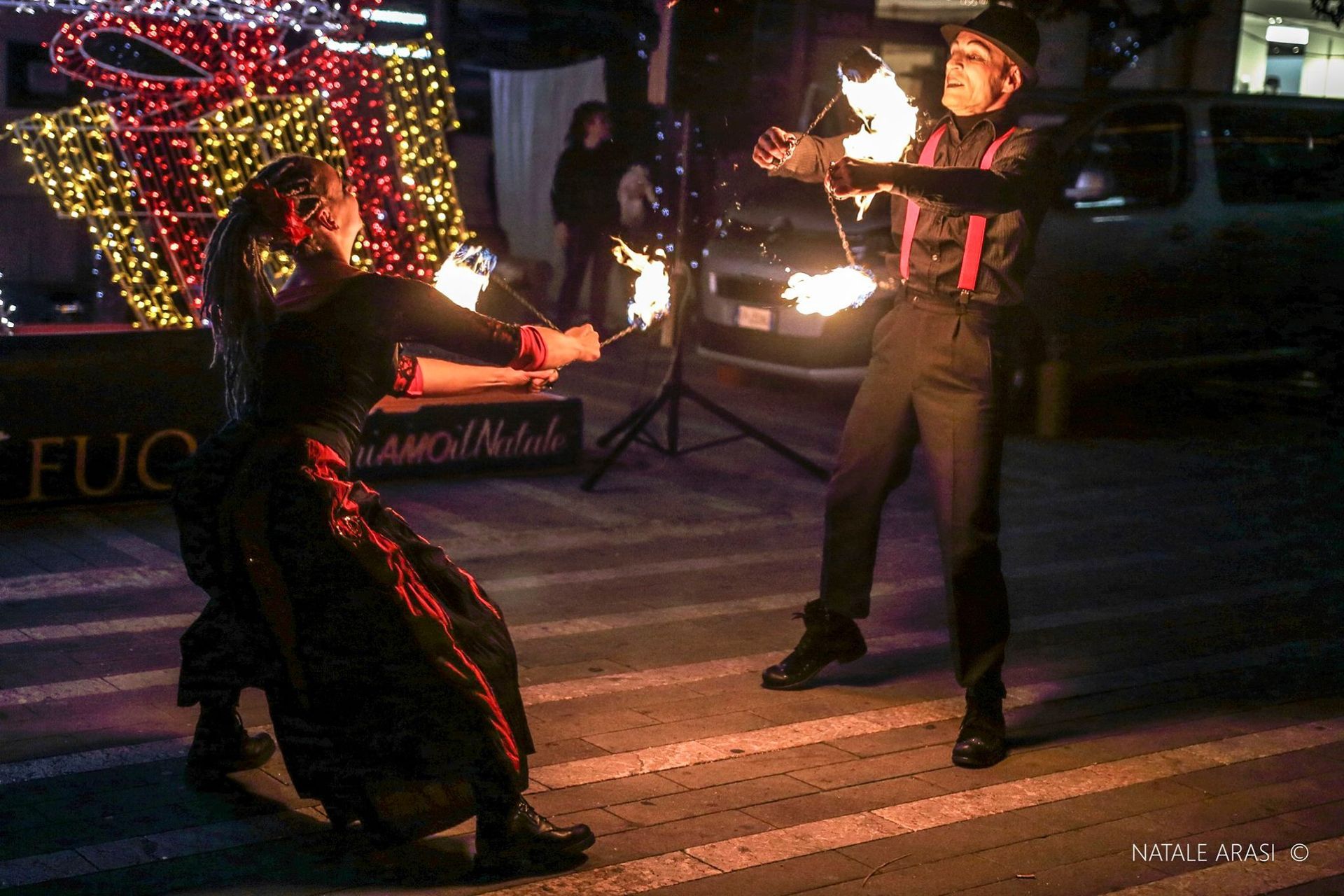 Un uomo e una donna tengono il fuoco nelle loro mani.