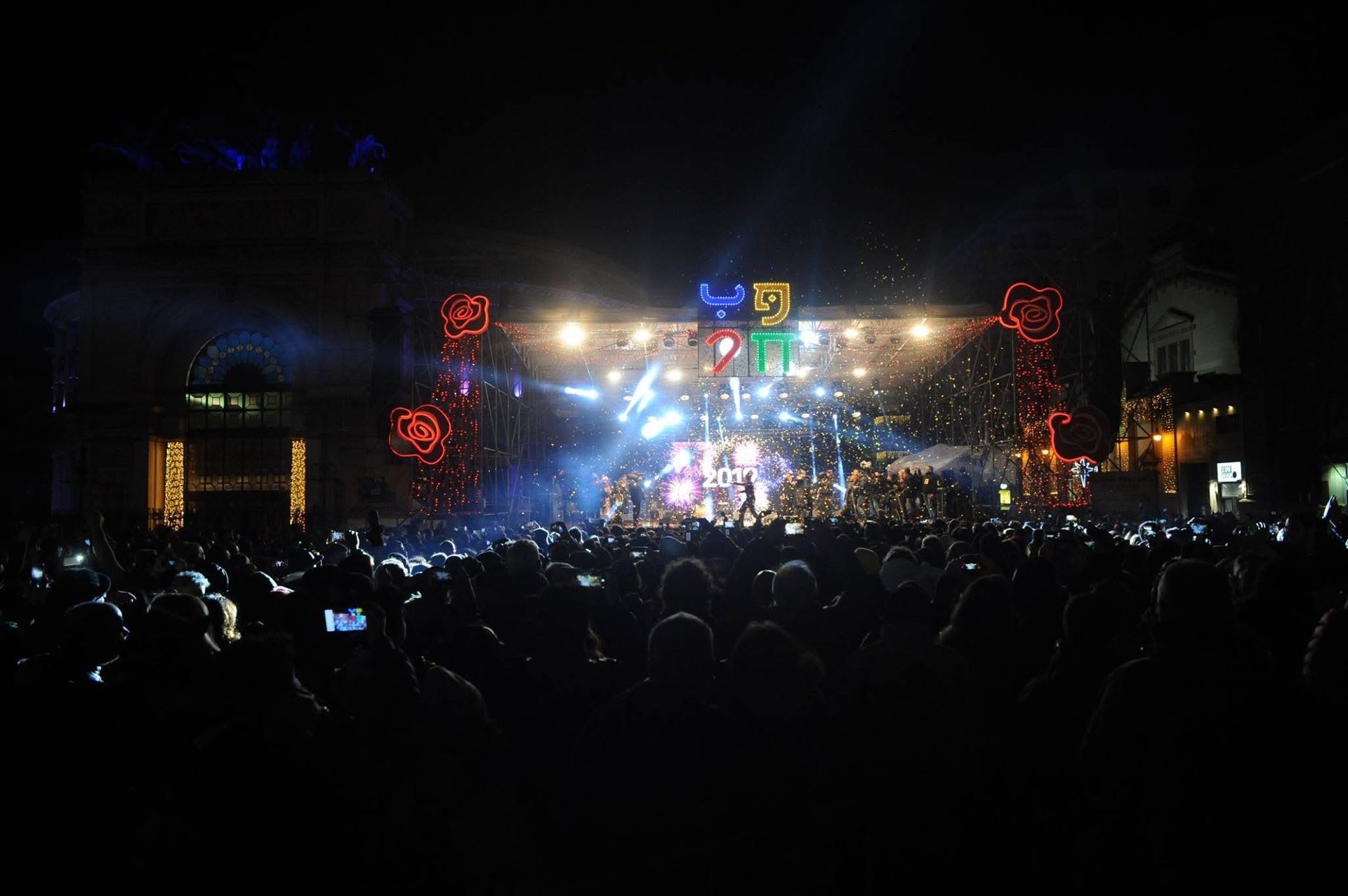 Una folla di persone sta guardando un concerto di notte.