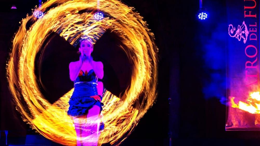 Una donna è in piedi davanti a un cerchio di fuoco.