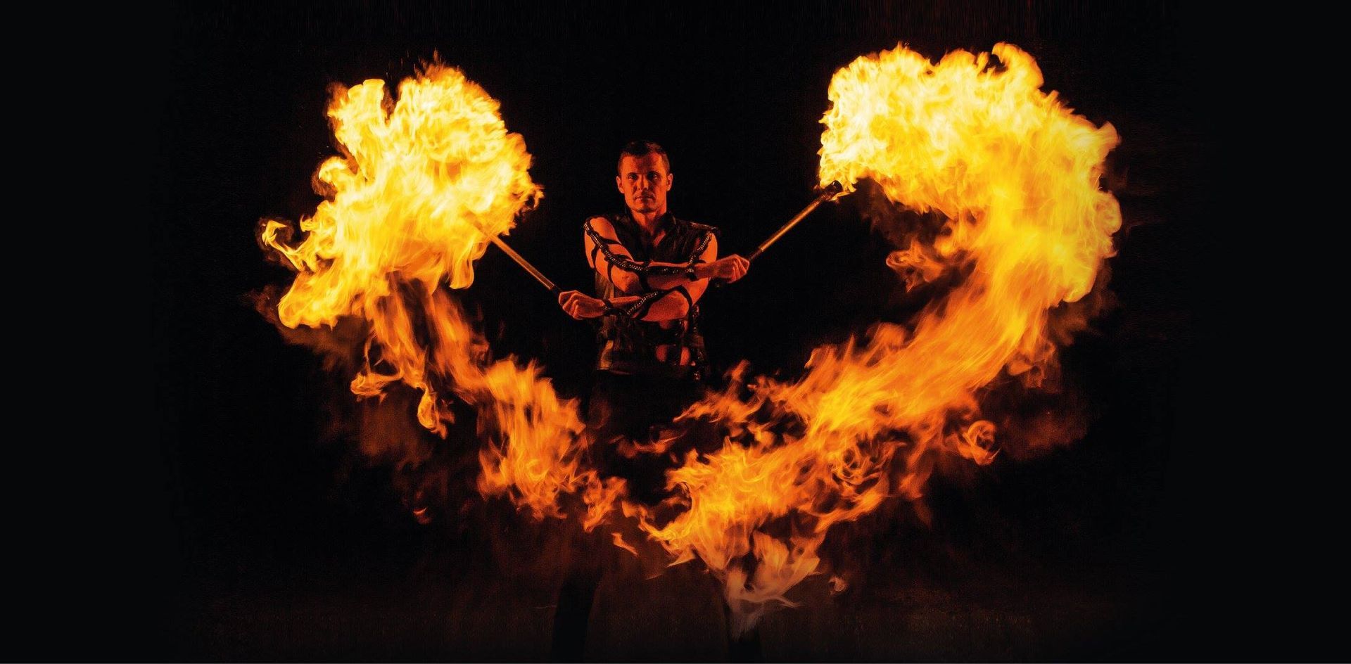 Un uomo tiene in mano due bastoncini di fuoco a forma di cuore.