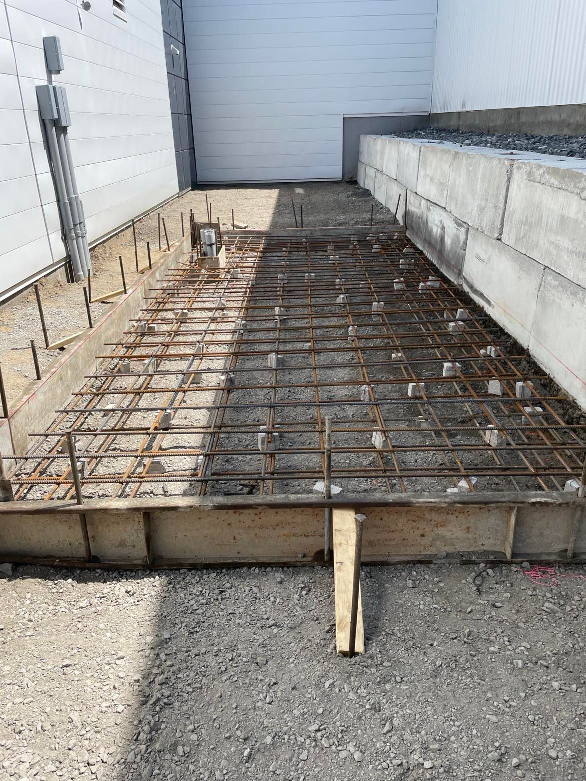 Une passerelle en béton est en cours de construction devant un bâtiment.