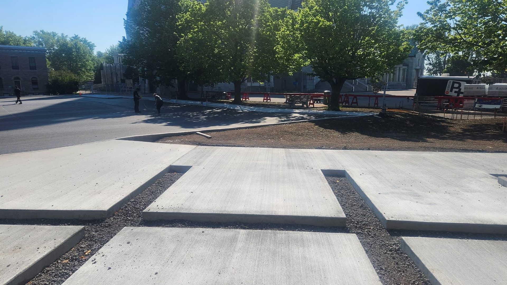 Une allée en béton avec quelques arbres en arrière-plan