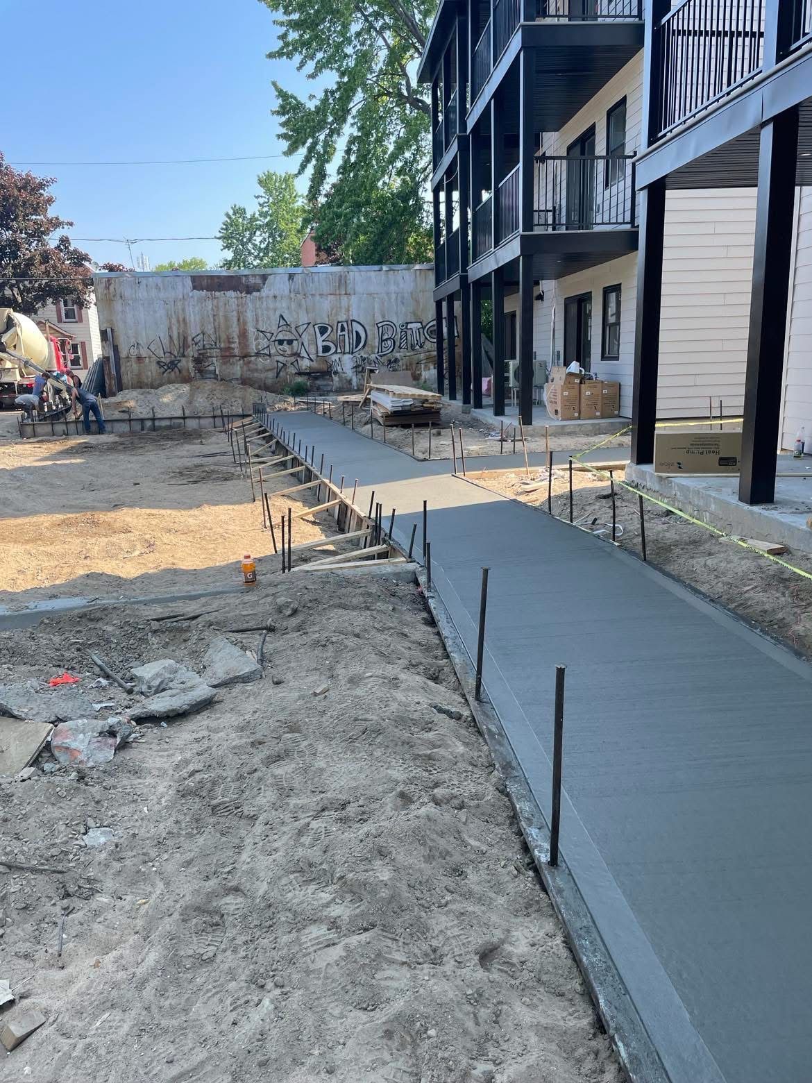 Une passerelle en béton est en cours de construction devant un bâtiment.
