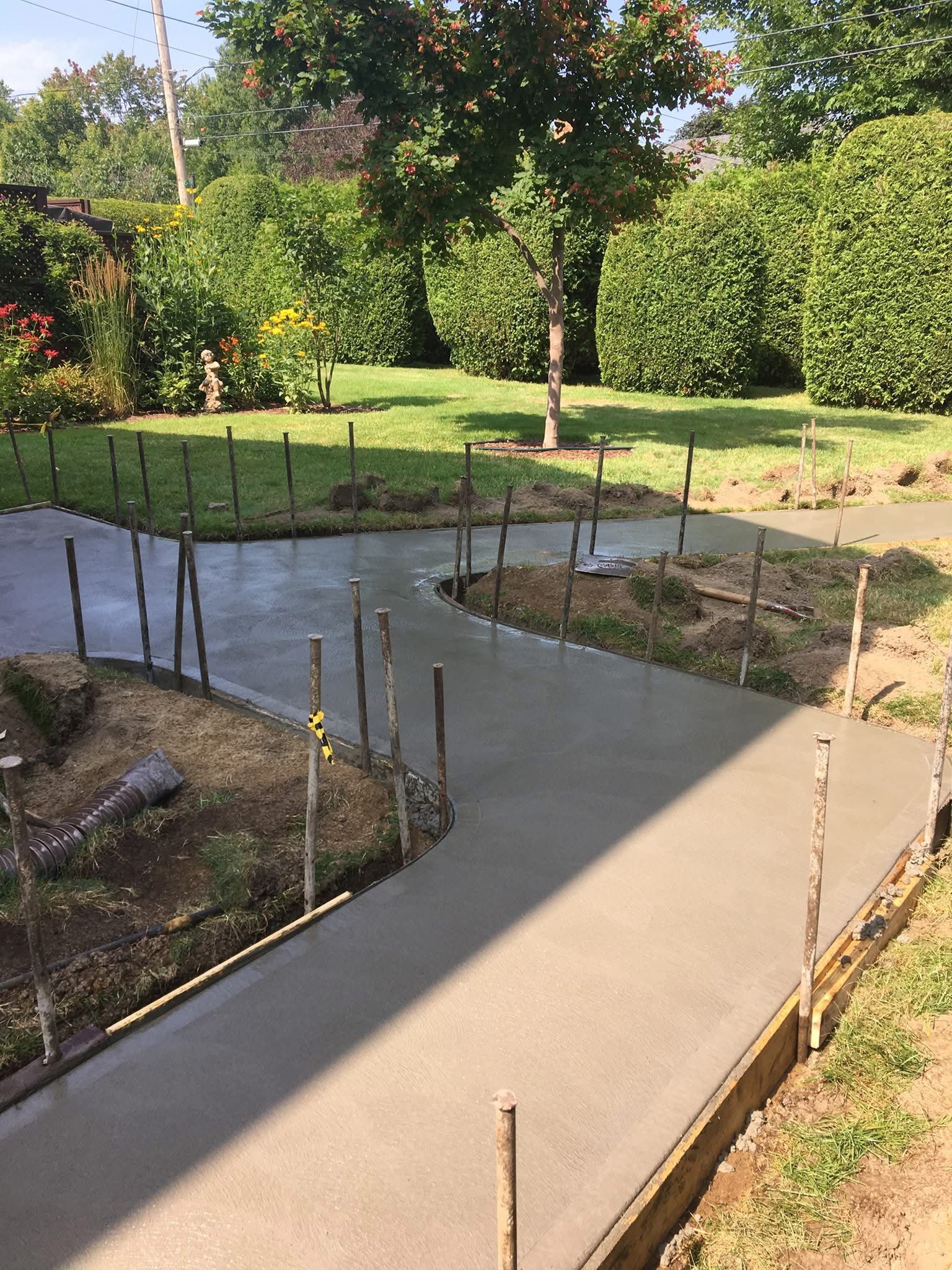 Une passerelle en béton est en cours de construction dans l'arrière-cour d'une maison.