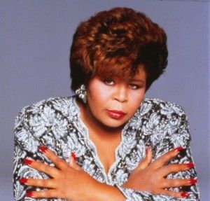 Singer, Vanessa Bell-Armstrong with red nails is hugging herself with her arms crossed